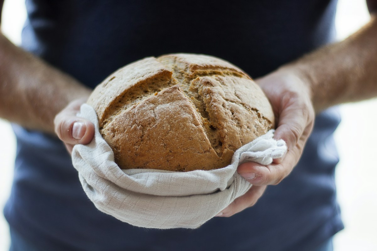 Hände halten ein frisch gebackenes Brot
