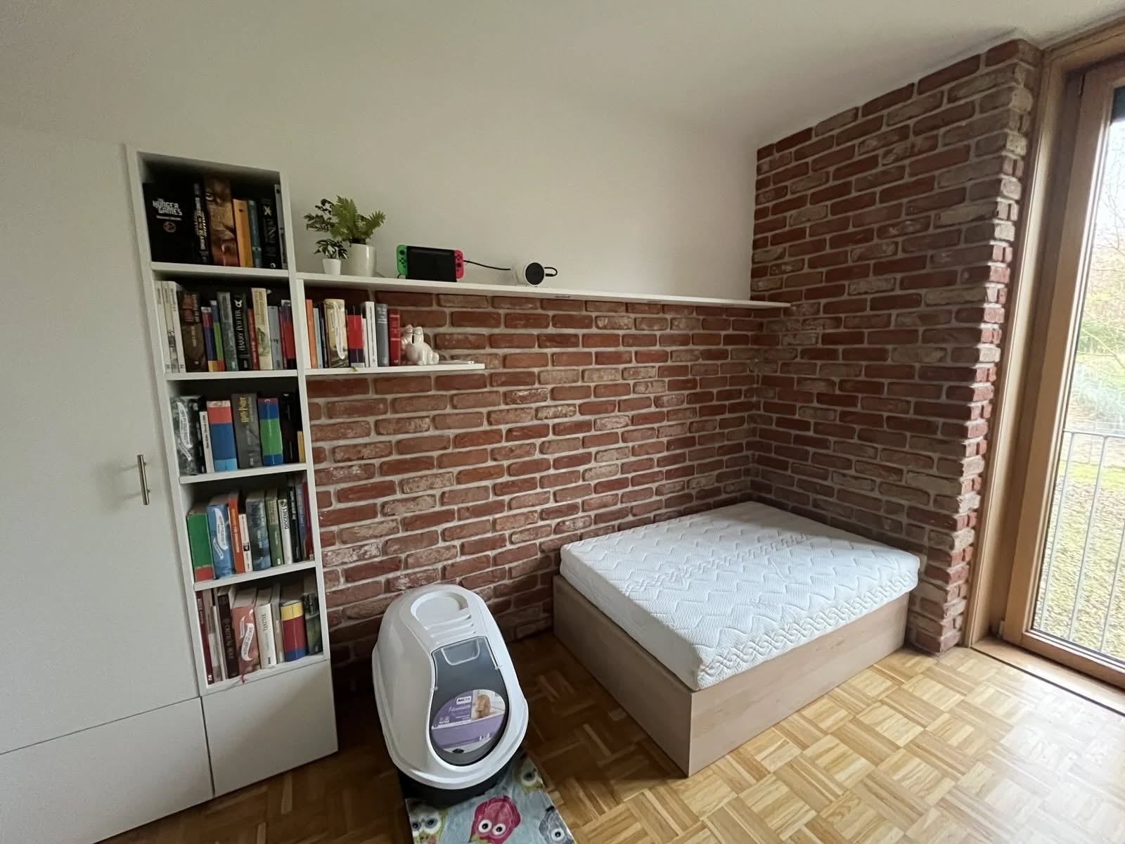 Gestaltete Klinkerwand mit Sitzplatz und Bücherregal